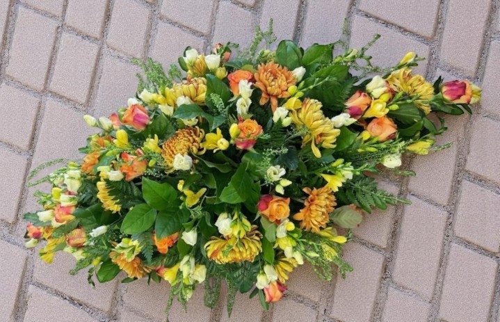 Orange tones casket spray
